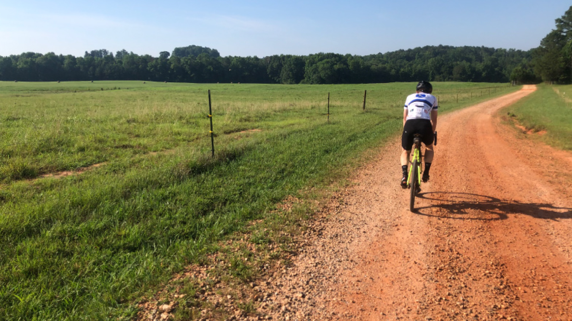 man riding bicycle on gravel road in rural Georgia, United States